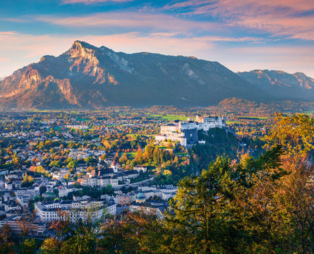 Fantastic cityscape of Salzburg with Hohensalzburg Fortress. Spectacular autumn sunrise on Eastern Alps. Picturesque morning landscape with Salzach river. Traveling concept background.