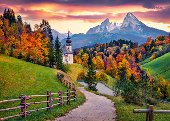Iconic picture of Bavaria with Maria Gern church with Hochkalter peak on background. Fantastic autumn sunrise in Alps. Superb evening landscape of Germany countryside. Traveling concept background..