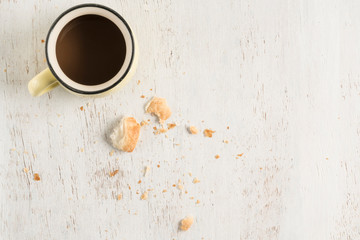leftover crumbs of bread and coffee mug on table