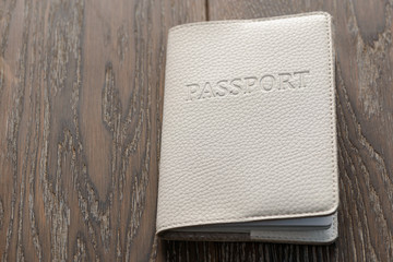 Closeup on a passport in white cover on wooden table
