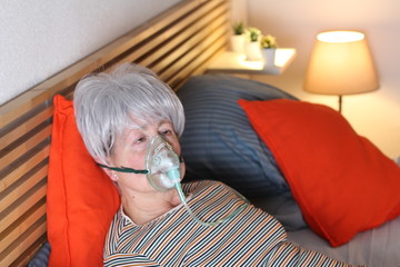 Senior woman using oxygen mask  