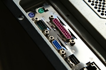 Various connection ports at the back of a desktop computer box. 