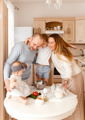 Obraz na płótnie Canvas Family cooks together in the kitchen and looks happy, mom, dad, baby, brother, sister, morning, love, care, laughter, fun, home