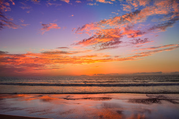 Fototapeta na wymiar Cloudy and orange sunset on the seashore