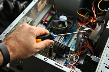 A technician repairing a desktop computer. This image has selective focus. 