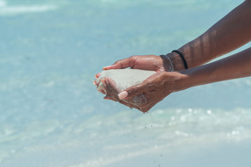 Hand holding white beach sand. Famous white silica sand. Whitehaven beach, Whitsundays. Turquoise ocean, white sand. Travel, holiday, vacation, paradise. Shot in Hill Inlet, Queenstown, Australia.