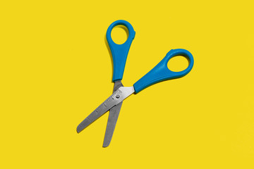 scissors lying on a yellow surface. concept of office supplies. free space for advertising text
