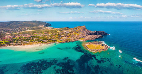 View from flying drone. Breathtaking summer view of Falcone cape and Torre della Pelosa tower. Sunny morning scene of La Pelosa village, Sardinia island, Italy, Europe. Traveling concept background..