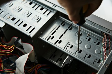 A technician repairing a desktop computer. This image has selective focus. 