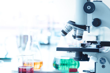 A laboratory microscope for scientific research in laboratory room with different laboratory glasswar background. Free copy space for text or design.