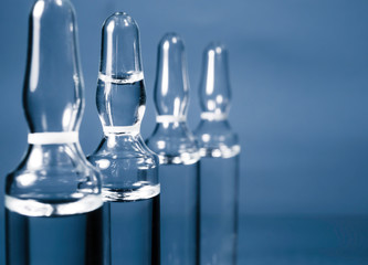 Blurred photo of ampoules with injection liquid for background. Coronavirus vaccine