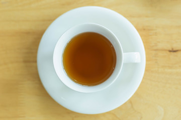 separate black tea cup on the wood floor, top view