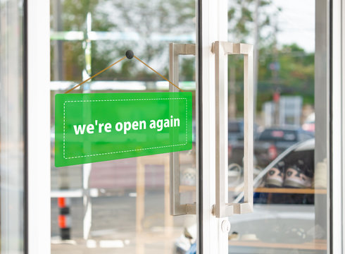 The green label has the message that "we're open again" on the entrance door.