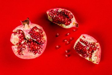 Cut red pomegranate photographed on a red background