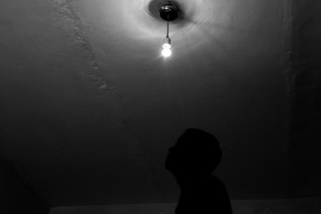 A man and a light bulb, a silhouette of a man under a light bulb.