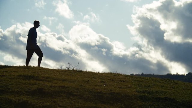 Un homme fait de la randonn&eacute;e en contre-jour dans la nature au abord des haute alpes lors d'un magnifique coucher de soleil.