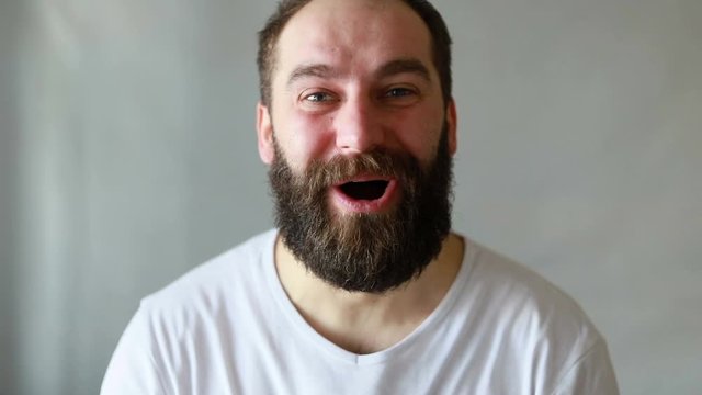 Portrait of handsome unshaved man screaming in astonishment and cannot believe, isolated over white background in studio closeup. Concept of emotions