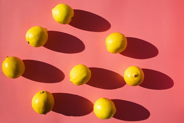 Flat lay composition with lemons on pink background,