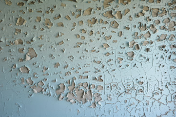 Light blue wall with cracked peeling paint surface texture