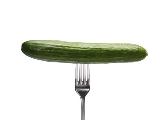 A fresh cucumber on a metal fork isolated on white background