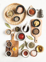 Various dry spices and sauces on a light background. Flat lay of small bowls with dijon mustard, olive oil, ketchup, capers and spices. T