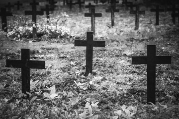 Vintage, retro black and white photo of old graves and crosses in a cemetery. Grainy, noisy,...