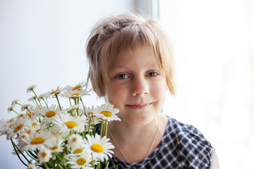 Portrait of a pretty little girl with   bouquet of daisies