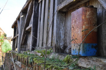 Fototapeta na wymiar Rusty can of oil in old brick wall covered in moss.