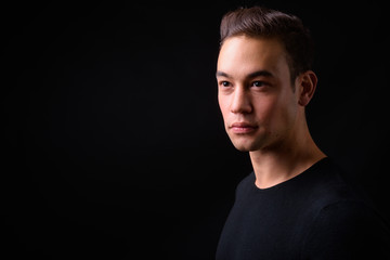 Naklejka premium Młody przystojny wieloetniczny mężczyzna na czarnym tle