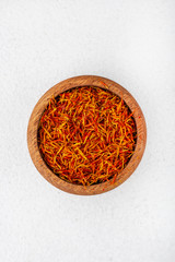 saffron in a wooden bowl in the center of the frame, top view, white background, spices