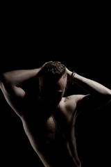 Unknown muscular guy posing on a black background.