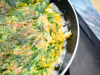 Omelet in Cha Om While the oil is boiling Cha-om is a pungent vegetable.High nutritional value