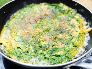 Omelet in Cha Om While the oil is boiling Cha-om is a pungent vegetable.High nutritional value