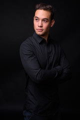 Obraz premium Young handsome multi ethnic businessman against black background