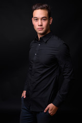 Young handsome multi ethnic businessman against black background