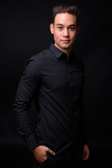 Fototapeta premium Young handsome multi ethnic businessman against black background