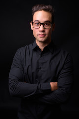 Young handsome multi ethnic businessman against black background