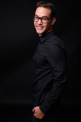 Fototapeta premium Young handsome multi ethnic businessman against black background
