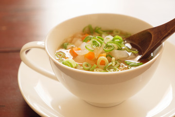 野菜スープをスプーンですくう