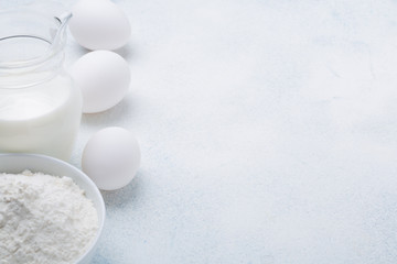 Obraz na płótnie Canvas Milk, flour and eggs on a white background. Ingredients for pie. Recipe