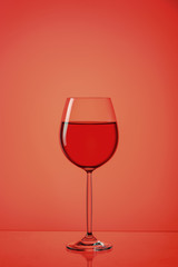 A glass of red wine on a red background with a reflection