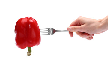 Close up female holds in hand red fresh red pepper on fork isolated on white background. Proper nutrition, vegetarian food, healthy lifestyle, vegetable concept. Advertising area copy space