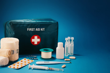 First aid kit content on top of blue background, with available copy space.
