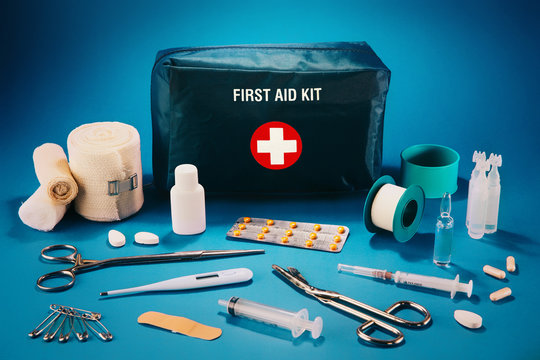 First aid kit content, isolated against blue background.
