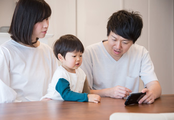 Fototapeta premium スマホを見る3人家族