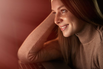 Fototapeta premium Happy woman checking laptop content sitting at home in the night
