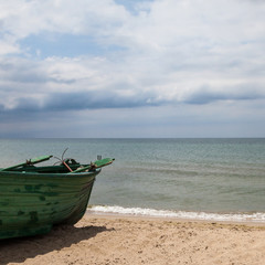 Fototapeta premium Old wooden green boat on the seashore.