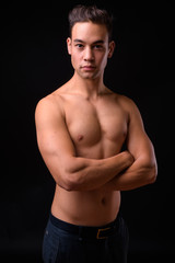 Fototapeta premium Young handsome multi ethnic man shirtless against black background
