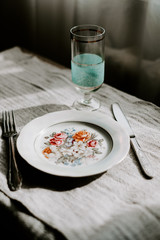 table setting for breakfast. floral plate, knife and fork, glass. 