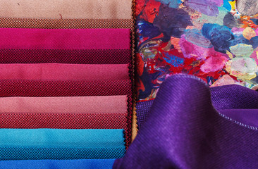 colorfull textile lies on a colorfull palette of the artist.Colored brushes and fabrics.